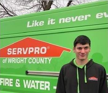 a man in front of a green SERVPRO truck