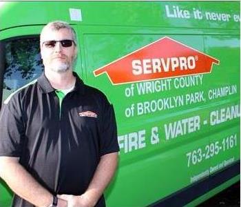 a man in front of a green SERVPRO truck
